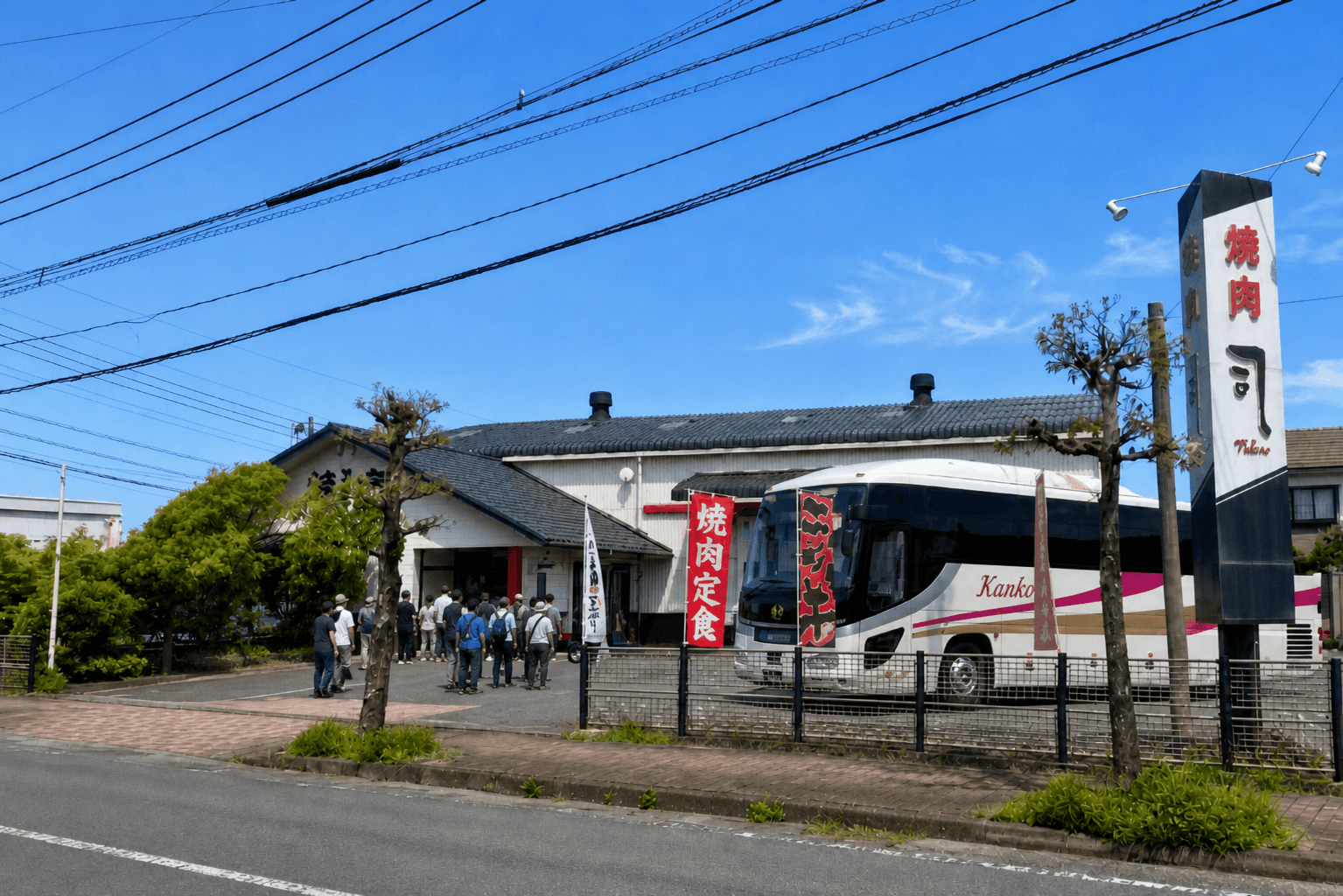 伊万里の焼肉司に到着した大型バスと店舗入口へ向かう団体のお客様