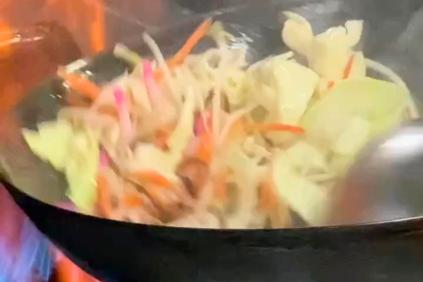 伊万里の焼肉司でちゃんぽんの野菜を高火力で炒める調理シーン